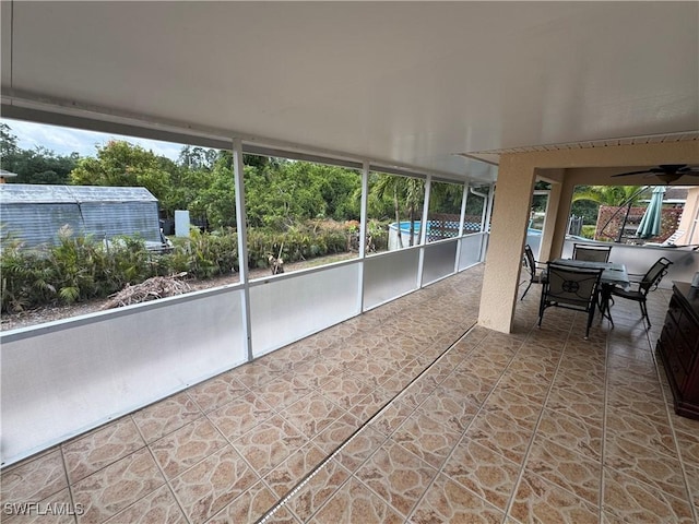 sunroom with outdoor dining space, a ceiling fan, and plenty of natural light