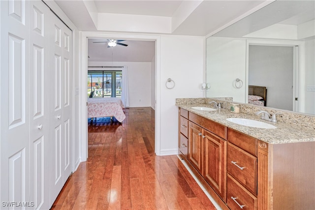 205 SW 42nd Ter, Cape Coral, FL 33914 - ensuite bathroom featuring double vanity, hardwood / wood-style floors, ceiling fan, baseboards, and a tray ceiling