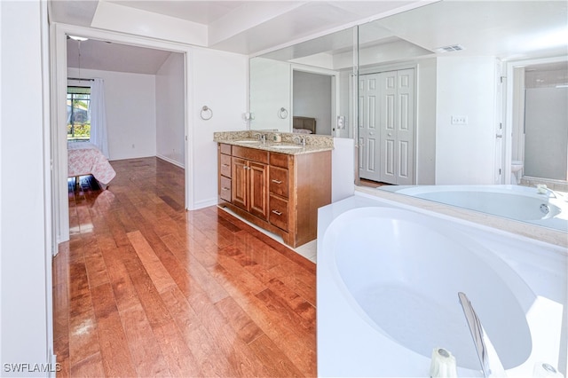 205 SW 42nd Ter, Cape Coral, FL 33914 - full bathroom featuring vanity, a garden tub, wood finished floors, and toilet