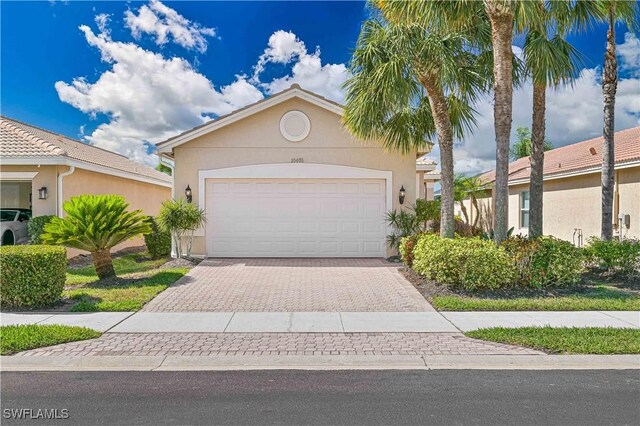 10486 Winged Elm Ln, Fort Myers, FL 33913 - view of front facade with stucco siding, driveway, and a garage