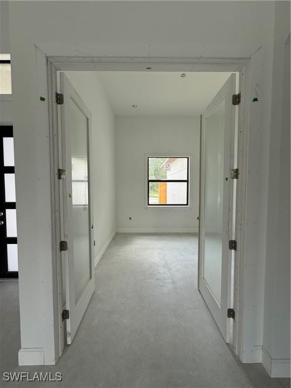 2481 24th Ave NE, Naples, FL 34120 - hallway featuring concrete flooring and french doors