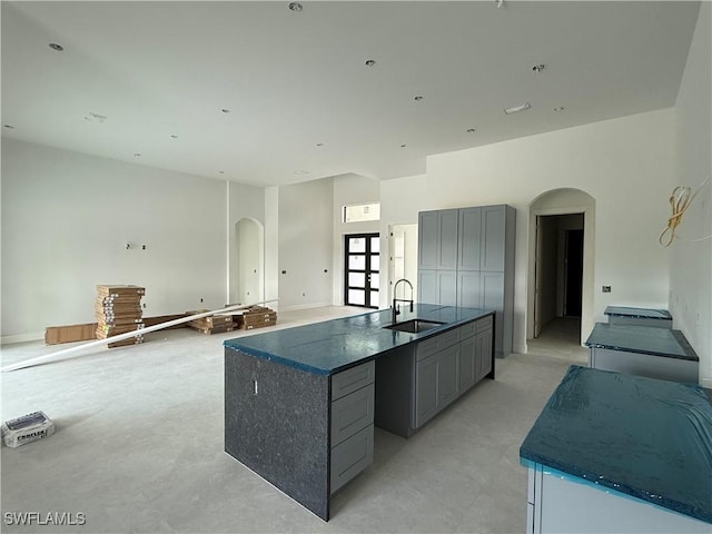 2481 24th Ave NE, Naples, FL 34120 - kitchen with arched walkways, gray cabinetry, and a kitchen island with sink