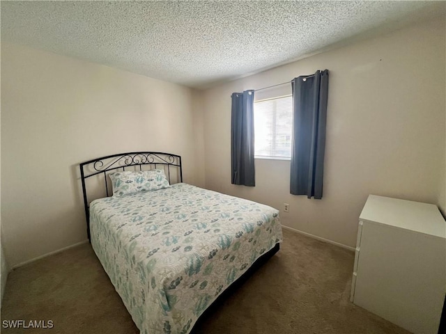 carpeted bedroom featuring a textured ceiling and baseboards