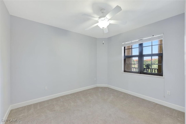 carpeted empty room featuring baseboards and ceiling fan