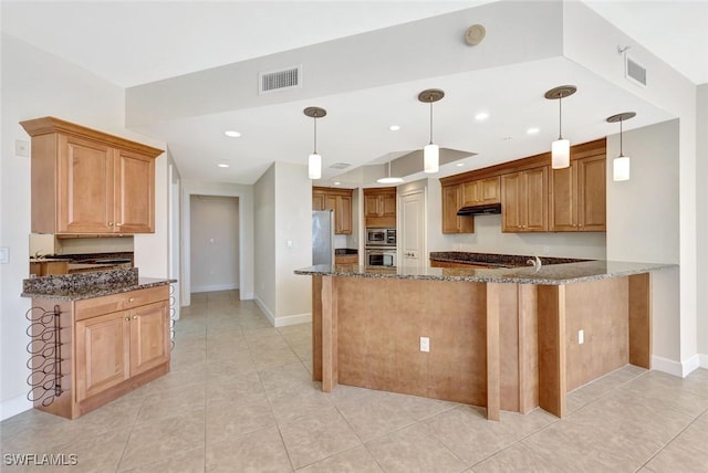 kitchen featuring under cabinet range hood, stainless steel appliances, visible vents, and dark stone countertops