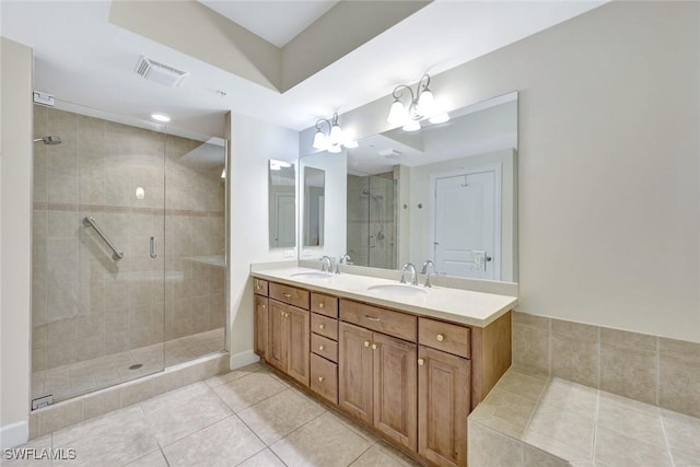 bathroom featuring visible vents, a sink, a stall shower, and tile patterned floors