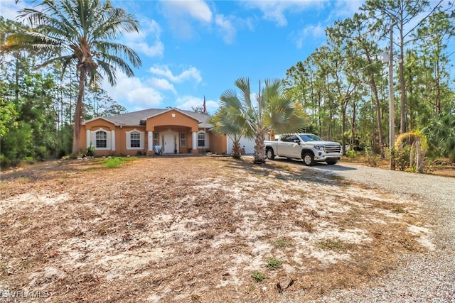 ranch-style home featuring gravel driveway