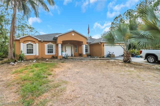 view of front of home with stucco siding, concrete driveway, and a garage
