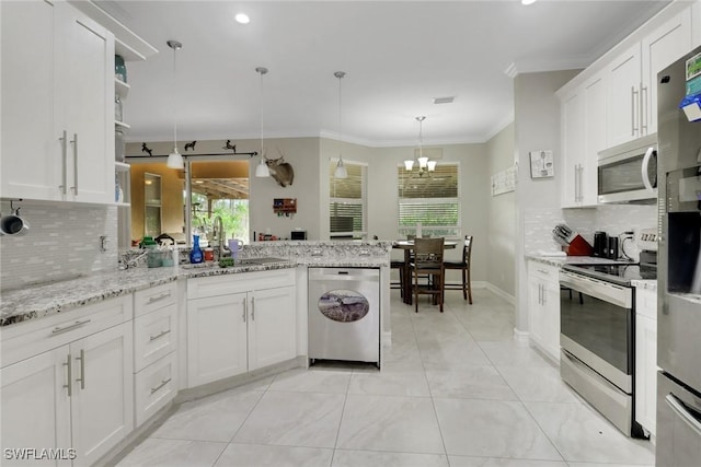 kitchen with stainless steel appliances, a sink, a peninsula, decorative backsplash, and ornamental molding