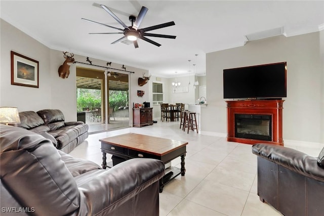 living room with ceiling fan, light tile patterned flooring, and a glass covered fireplace