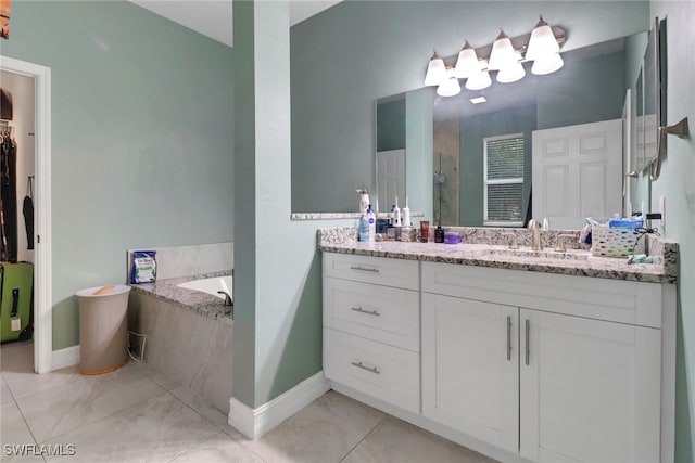 bathroom with baseboards, vanity, a shower stall, and a garden tub