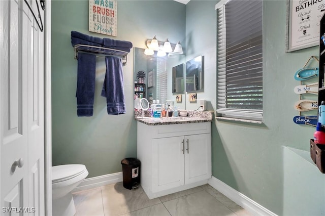 bathroom featuring baseboards, vanity, and toilet