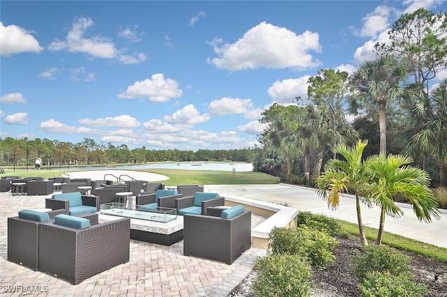 view of patio with an outdoor living space with a fire pit and a water view