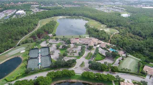 drone / aerial view featuring a forest view, view of golf course, and a water view