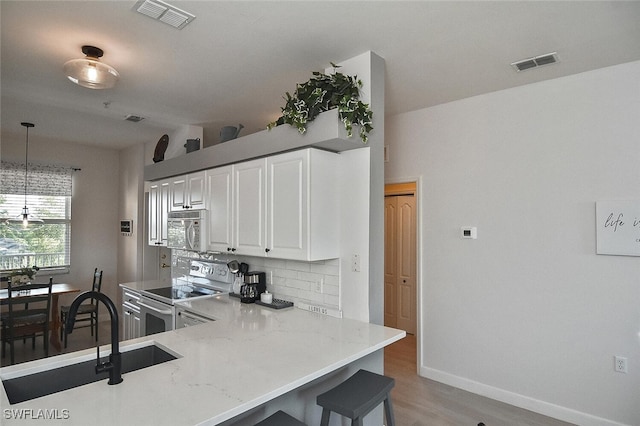 kitchen featuring white microwave, visible vents, a sink, and electric range oven