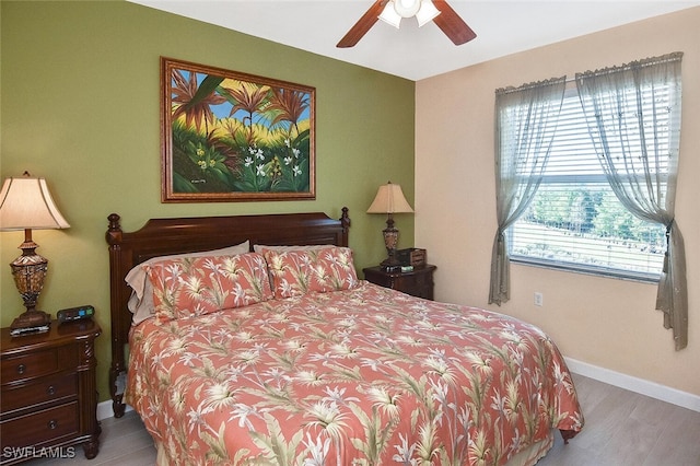 bedroom featuring ceiling fan, baseboards, and wood finished floors