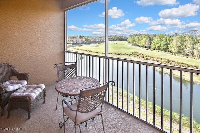 balcony with a water view and golf course view