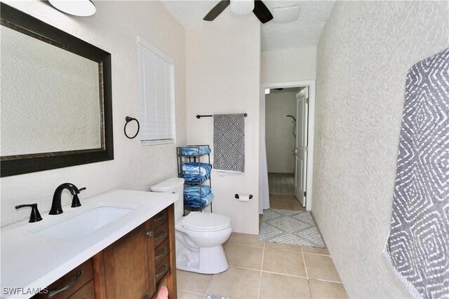 2061 Santa Barbara Blvd, Naples, FL 34116 - bathroom with a textured wall, toilet, vanity, ceiling fan, and tile patterned floors