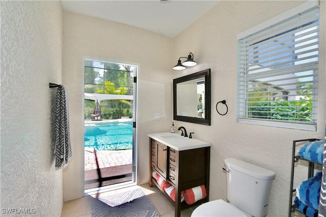 2061 Santa Barbara Blvd, Naples, FL 34116 - bathroom with healthy amount of natural light, a textured wall, toilet, vanity, and tile patterned flooring