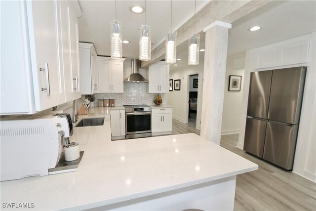 2061 Santa Barbara Blvd, Naples, FL 34116 - kitchen with stainless steel appliances, wall chimney exhaust hood, a sink, a peninsula, and light countertops