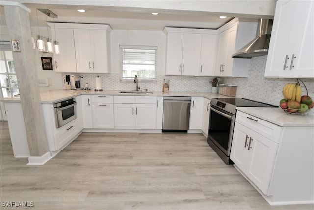 2061 Santa Barbara Blvd, Naples, FL 34116 - kitchen with stainless steel appliances, wall chimney exhaust hood, a sink, white cabinets, and light countertops