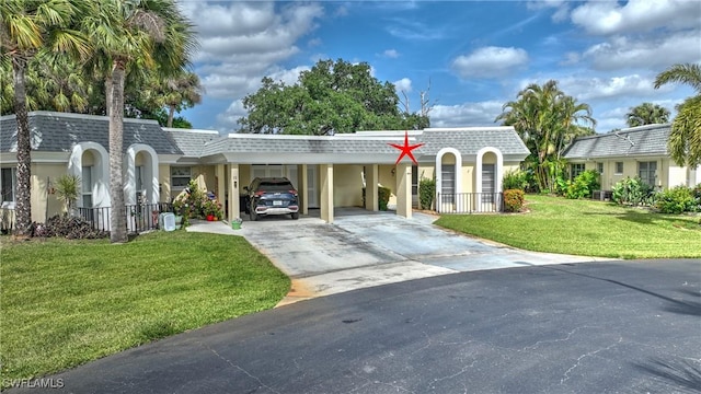 view of front of property with a front lawn, driveway, mansard roof, and a shingled roof