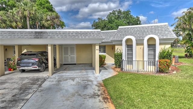 view of front of property featuring concrete driveway, a front lawn, a carport, stucco siding, and roof with shingles