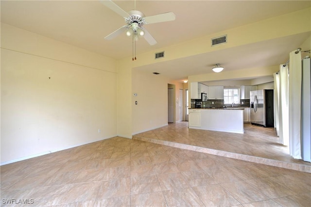 unfurnished living room with a ceiling fan and visible vents