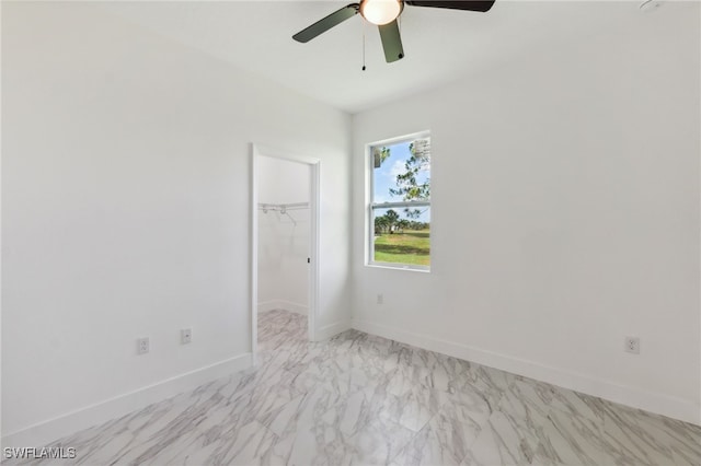 8 Cleat Ct, Placida, FL 33946 - unfurnished bedroom featuring a walk in closet, light marble finish floors, a closet, baseboards, and ceiling fan