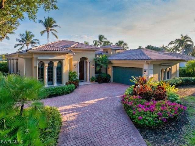 1716 Venezia Way, Naples, FL 34105 - mediterranean / spanish home with stucco siding, an attached garage, decorative driveway, and a tile roof
