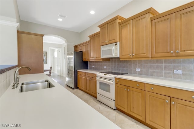 14070 Tivoli Ter, Bonita Springs, FL 34135 - kitchen with a sink, arched walkways, white appliances, and light countertops