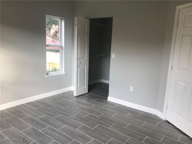 unfurnished bedroom with a closet and baseboards