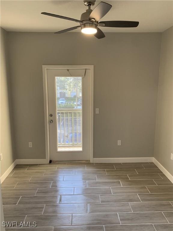 spare room with baseboards, a ceiling fan, and wood tiled floor