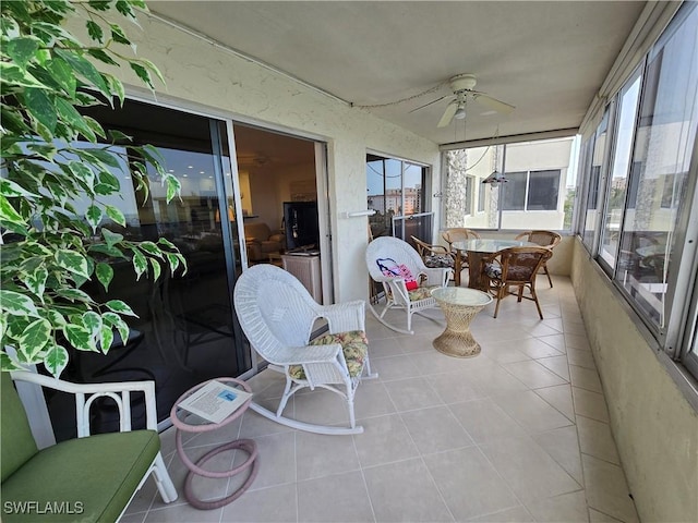 sunroom with ceiling fan and tile patterned floors