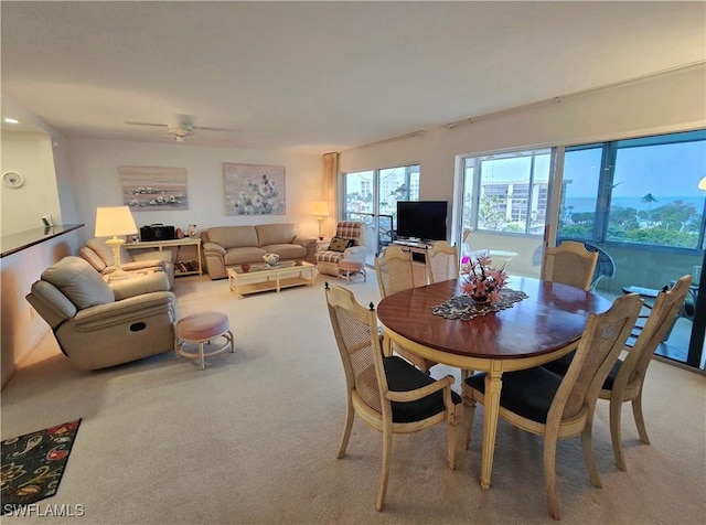 dining area with light carpet and ceiling fan