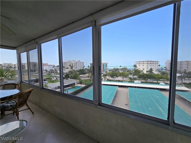 sunroom / solarium with tile patterned flooring and a view of city