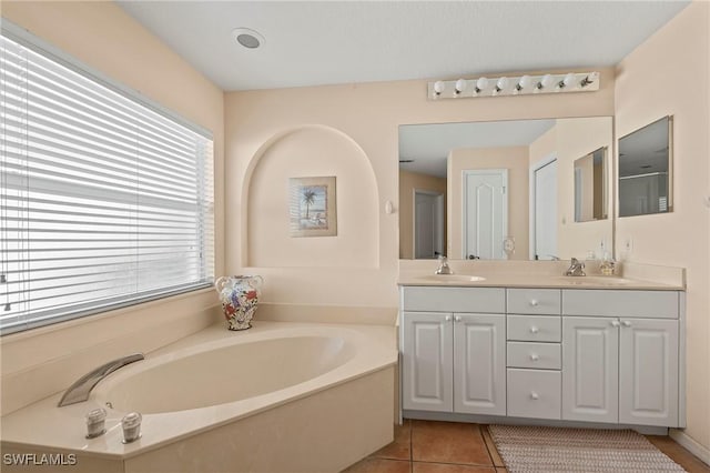 bathroom with double vanity, tile patterned flooring, a bath, and a sink