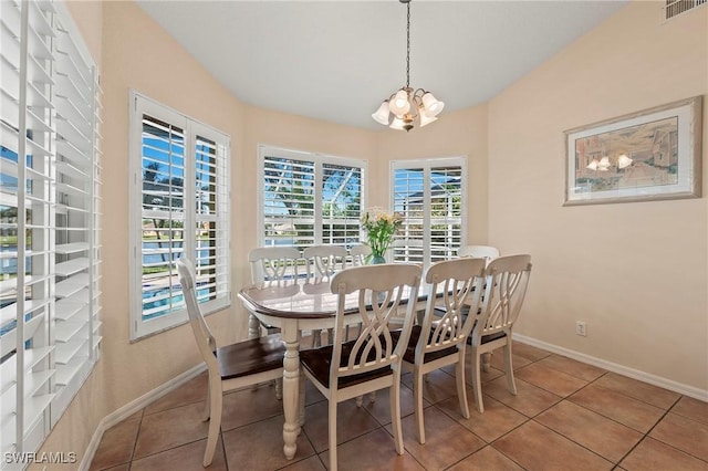 tiled dining area with visible vents, a notable chandelier, and baseboards