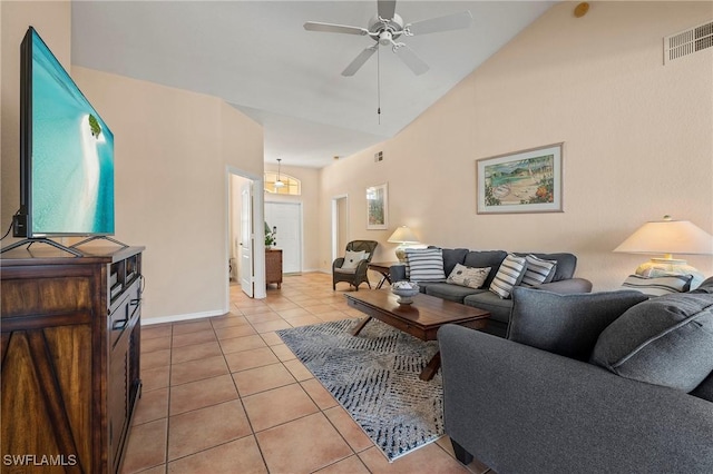living area featuring lofted ceiling, light tile patterned floors, visible vents, baseboards, and a ceiling fan