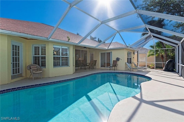 pool with a patio, a lanai, and ceiling fan