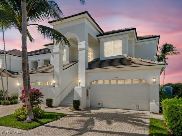 1749 Gulfstar Dr S Unit 404, Naples, FL 34112 - mediterranean / spanish house with a tile roof, stairway, a garage, and stucco siding