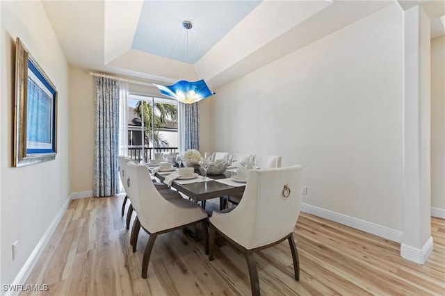 1749 Gulfstar Dr S Unit 404, Naples, FL 34112 - dining area featuring light wood-style flooring, baseboards, and a raised ceiling