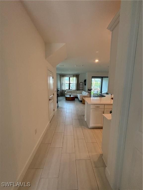 hallway featuring baseboards and recessed lighting