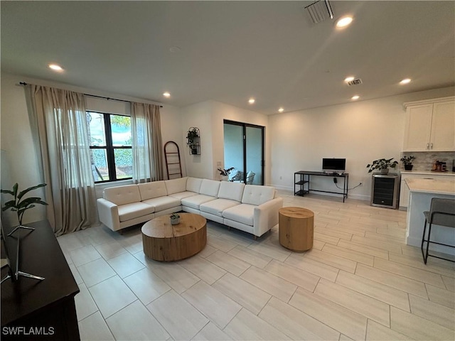 living room featuring recessed lighting, visible vents, and beverage cooler
