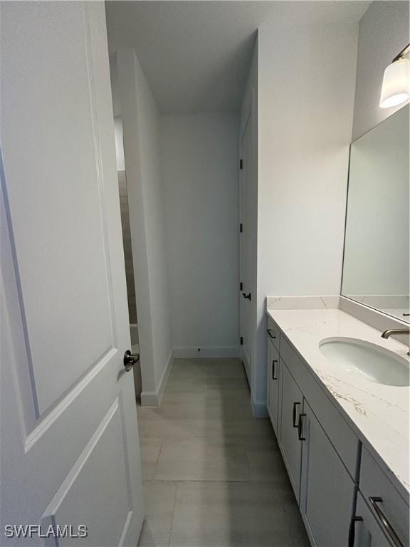 bathroom featuring tile patterned floors, vanity, and baseboards