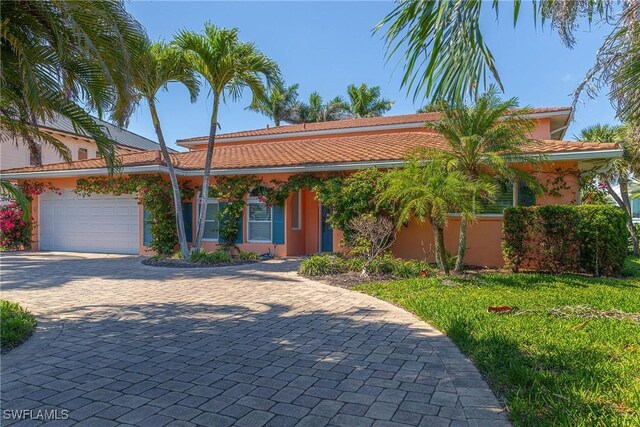 419 Pine Ave, Naples, FL 34108 - ranch-style house with stucco siding, decorative driveway, an attached garage, a front yard, and a tiled roof