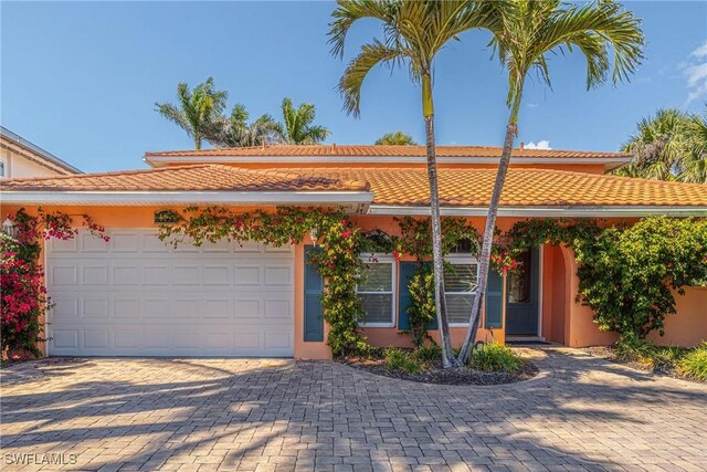 419 Pine Ave, Naples, FL 34108 - single story home with a garage, stucco siding, a tiled roof, and decorative driveway