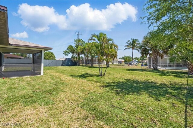 2203 SE Santa Barbara Pl, Cape Coral, FL 33990 - view of yard with a sunroom and fence