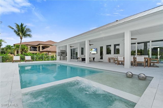 view of pool featuring a ceiling fan, outdoor dining area, fence, a patio, and a pool with connected hot tub