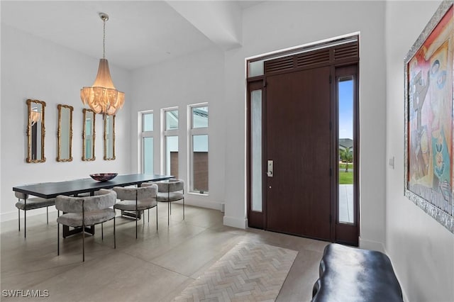 entryway featuring baseboards and a notable chandelier